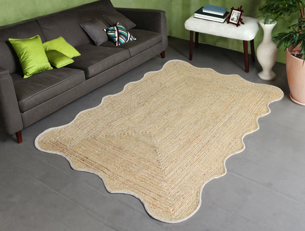 Handwoven natural jute scalloped area rug with white border placed in a modern living room featuring eco-friendly braided craftsmanship.