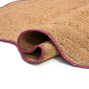 Handwoven natural jute scalloped area rug with elegant pink border for modern boho living room decor.