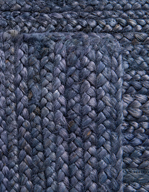 Navy blue handwoven textured area rug styled in a cozy modern living room with cream sofa and wooden furniture