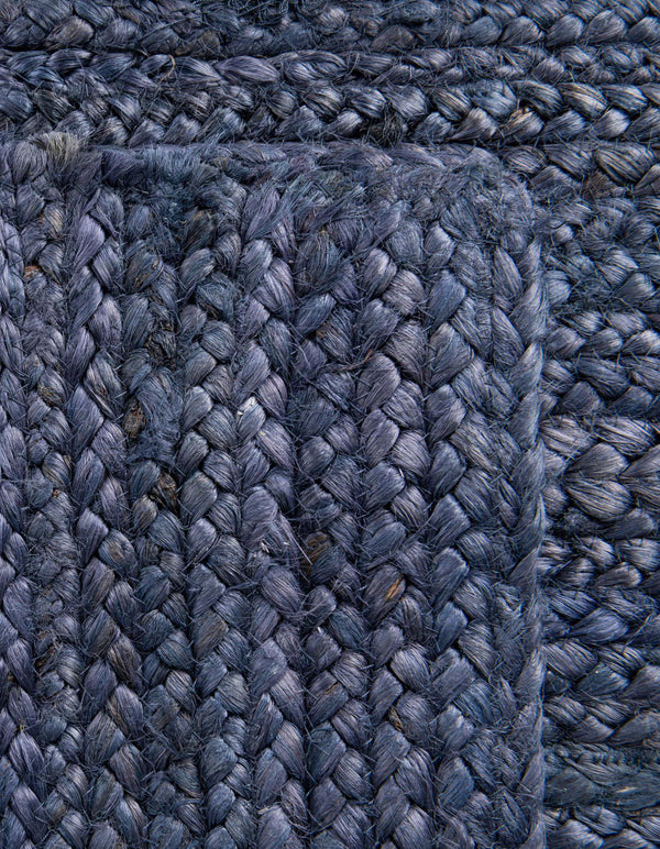 Navy blue handwoven textured area rug styled in a cozy modern living room with cream sofa and wooden furniture