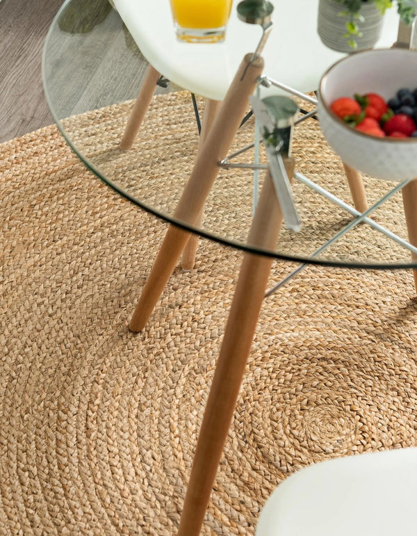 Round handwoven natural jute rug with braided spiral weave design in earthy brown and tan tones for boho rustic home décor.