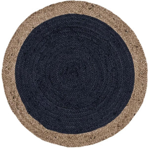 A modern circular patterned round rug placed on a wooden floor in a styled living room setu
