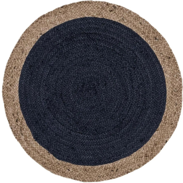 A modern circular patterned round rug placed on a wooden floor in a styled living room setu