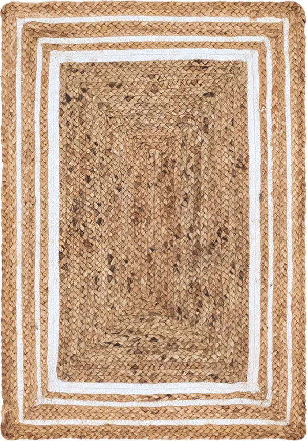 Natural woven jute rug with a navy blue double-border design, styled on a rustic wooden floor beside a wooden bench, striped throw blanket, and green potted fern.