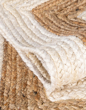 Hand-braided round jute and cotton area rug with alternating concentric natural brown and off-white striped circles.