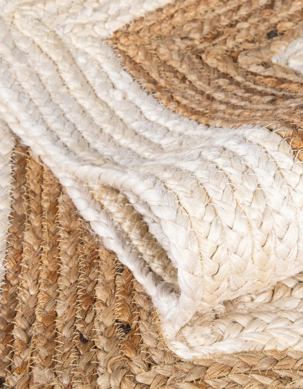 Hand-braided round jute and cotton area rug with alternating concentric natural brown and off-white striped circles.