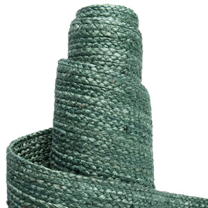 Deep green handwoven braided jute runner rug placed on a hardwood floor alongside a wooden bench in an entryway.