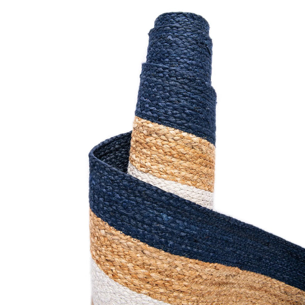 Natural jute runner rug with ivory and navy blue borders styled in a bright modern hallway with wooden flooring and neutral furniture