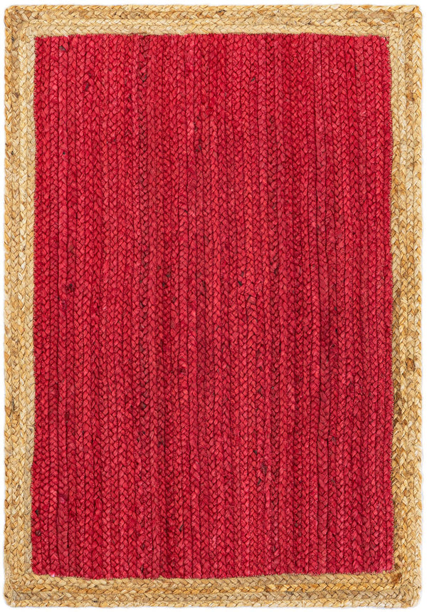 Red handwoven textured jute area rug with natural border styled on a wooden floor in a cozy rustic entryway