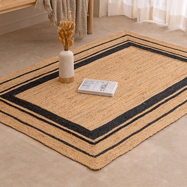 Handwoven black and natural jute rug with geometric border