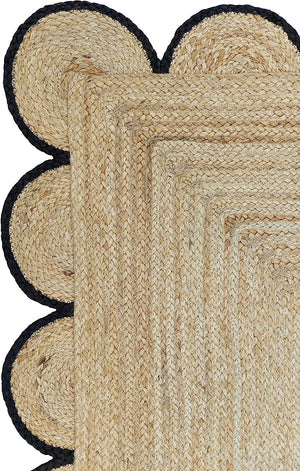 Handmade natural braided jute rug with black scalloped border displayed in a modern boho living room, eco-friendly woven area rug for living room, bedroom, farmhouse and minimalist home decor.