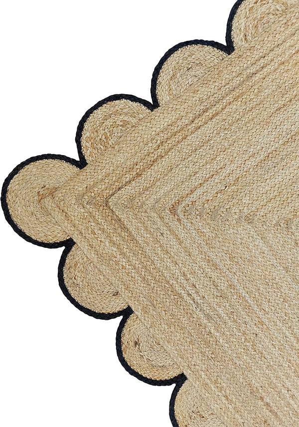 Handmade natural braided jute rug with black scalloped border displayed in a modern boho living room, eco-friendly woven area rug for living room, bedroom, farmhouse and minimalist home decor.
