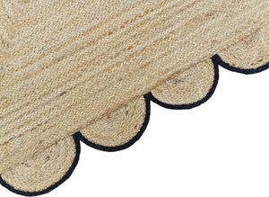 Handmade natural braided jute rug with black scalloped border displayed in a modern boho living room, eco-friendly woven area rug for living room, bedroom, farmhouse and minimalist home decor.