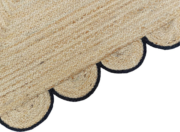 Handmade natural braided jute rug with black scalloped border displayed in a modern boho living room, eco-friendly woven area rug for living room, bedroom, farmhouse and minimalist home decor.