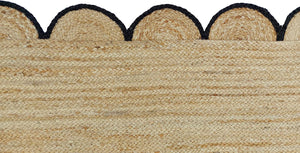 Handmade natural braided jute rug with black scalloped border displayed in a modern boho living room, eco-friendly woven area rug for living room, bedroom, farmhouse and minimalist home decor.