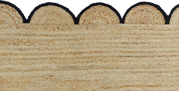 Handmade natural braided jute rug with black scalloped border displayed in a modern boho living room, eco-friendly woven area rug for living room, bedroom, farmhouse and minimalist home decor.