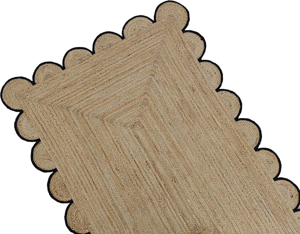 Handmade natural braided jute rug with black scalloped border displayed in a modern boho living room, eco-friendly woven area rug for living room, bedroom, farmhouse and minimalist home decor.