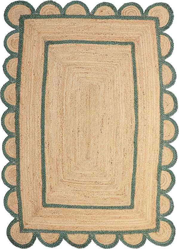 Handwoven natural jute scalloped area rug with sage green border styled in a modern Scandinavian living room.