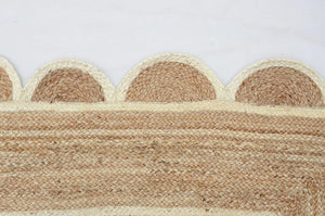 Handwoven natural jute area rug in beige and off-white with scalloped edge border for living room and bedroom