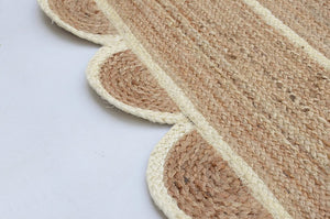 Handwoven natural jute area rug in beige and off-white with scalloped edge border for living room and bedroom