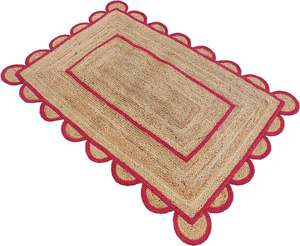 Handwoven natural jute area rug with bold red scalloped border and braided rectangular design