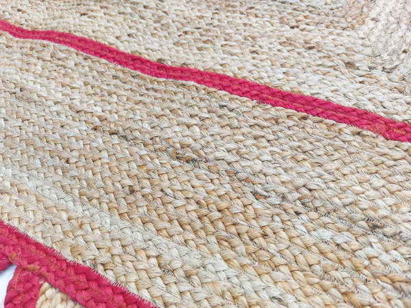 Handwoven natural jute area rug with bold red scalloped border and braided rectangular design