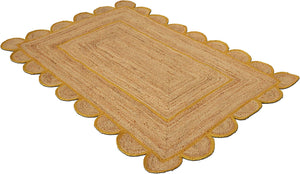 Handmade natural jute scalloped area rug with mustard border in a modern boho living room