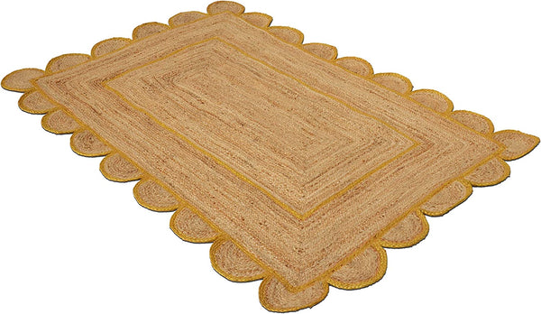 Handmade natural jute scalloped area rug with mustard border in a modern boho living room