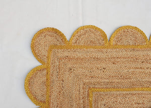 Handmade natural jute scalloped area rug with mustard border in a modern boho living room