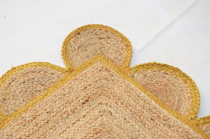 Handmade natural jute scalloped area rug with mustard border in a modern boho living room