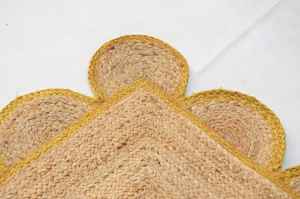 Handmade natural jute scalloped area rug with mustard border in a modern boho living room