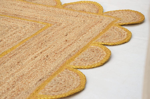 Handmade natural jute scalloped area rug with mustard border in a modern boho living room