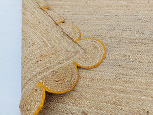 Handwoven Natural Jute Area Rug with Mustard Scalloped Border Styled in a Modern Scandinavian Living Room