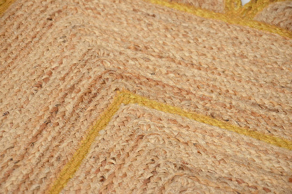 Handmade natural jute scalloped area rug with mustard border in a modern boho living room