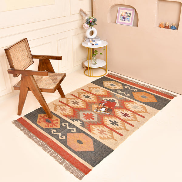 Handmade wool jute kilim area rug featuring Southwestern tribal geometric patterns in beige, charcoal, rust, and ivory for boho farmhouse home décor.