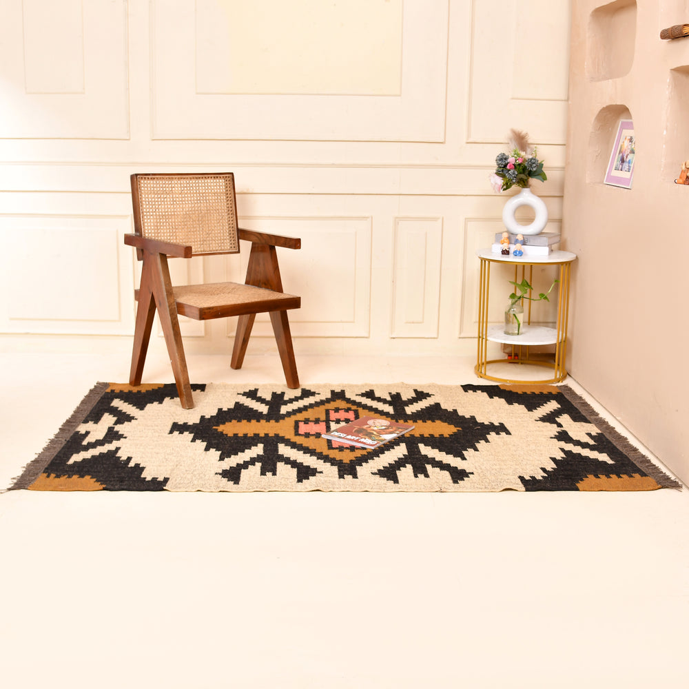Handwoven ivory wool jute Kilim area rug featuring bold tribal geometric patterns with black, camel, and blush accents in a modern living room.