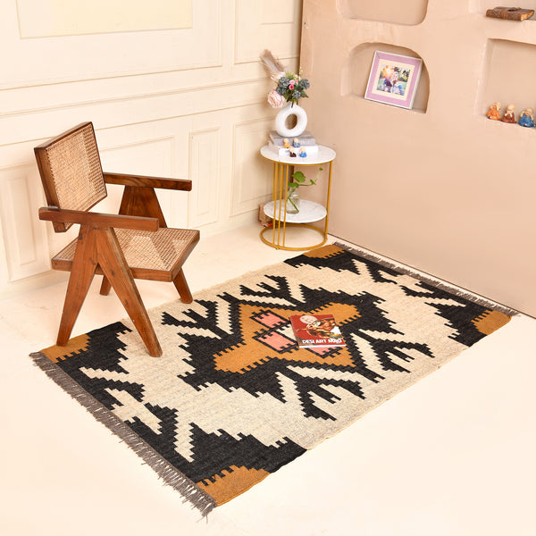 Handwoven ivory wool jute Kilim area rug featuring bold tribal geometric patterns with black, camel, and blush accents in a modern living room.