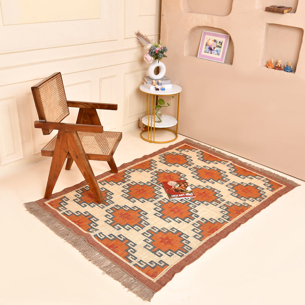 Handwoven wool jute kilim area rug with geometric tribal pattern in terracotta, ivory, and blue tones placed in a modern living room.