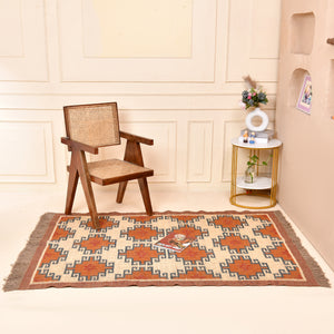 Handwoven wool jute kilim area rug with geometric tribal pattern in terracotta, ivory, and blue tones placed in a modern living room.