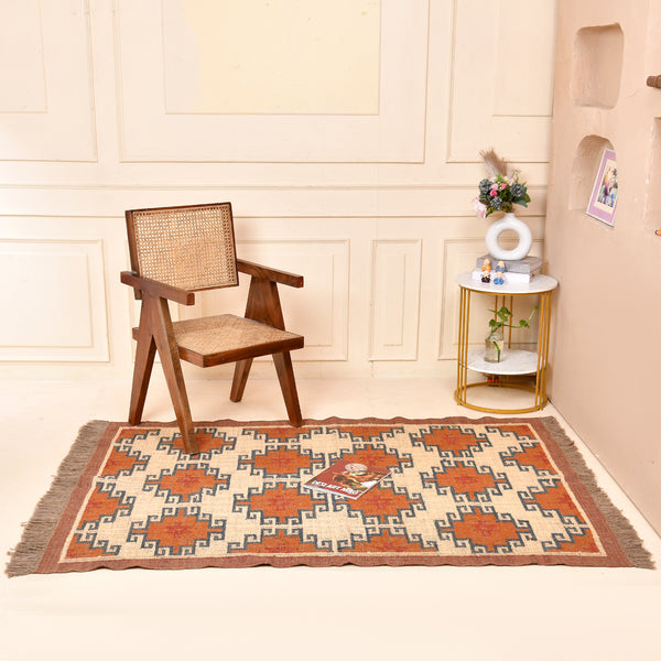 Handwoven wool jute kilim area rug with geometric tribal pattern in terracotta, ivory, and blue tones placed in a modern living room.