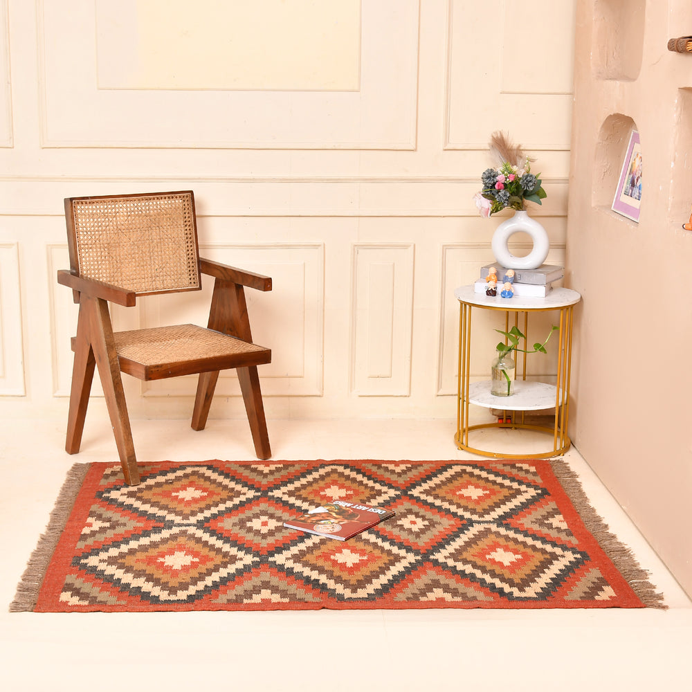 Handwoven geometric wool jute kilim area rug with tribal diamond pattern in terracotta, beige, charcoal, and ivory colors for living room and bedroom décor.