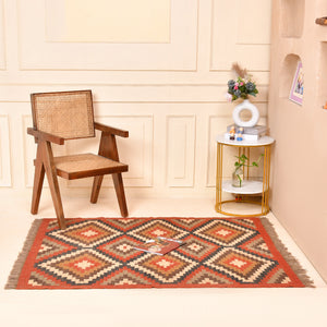 Handwoven geometric wool jute kilim area rug with tribal diamond pattern in terracotta, beige, charcoal, and ivory colors for living room and bedroom décor.