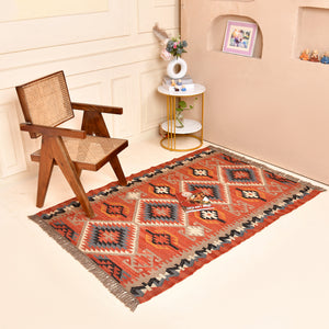 Handwoven terracotta geometric wool Kilim area rug with tribal diamond patterns and fringe, perfect for boho, farmhouse, rustic, and Southwestern home décor.
