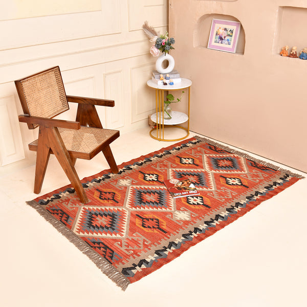 Handwoven terracotta geometric wool Kilim area rug with tribal diamond patterns and fringe, perfect for boho, farmhouse, rustic, and Southwestern home décor.