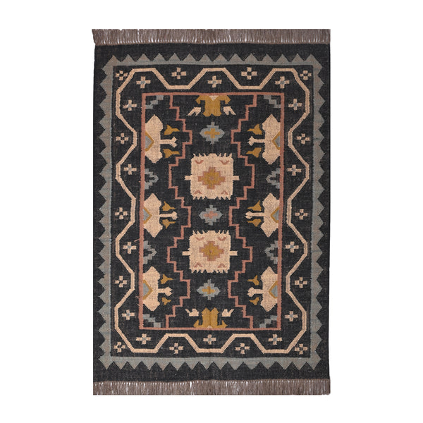 Handwoven black wool jute Kilim area rug with tribal geometric pattern and fringe in a modern living room.