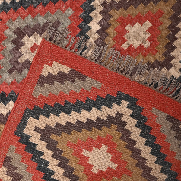 Handwoven geometric wool jute kilim area rug with tribal diamond pattern in terracotta, beige, charcoal, and ivory colors for living room and bedroom décor.