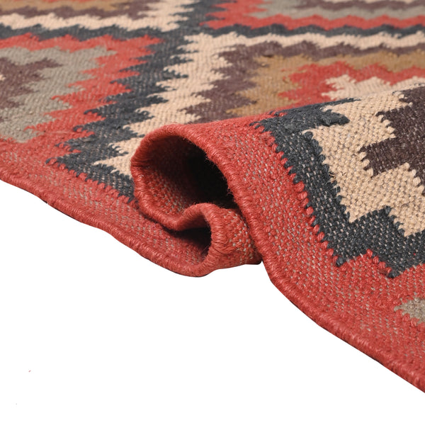 Handwoven geometric wool jute kilim area rug with tribal diamond pattern in terracotta, beige, charcoal, and ivory colors for living room and bedroom décor.