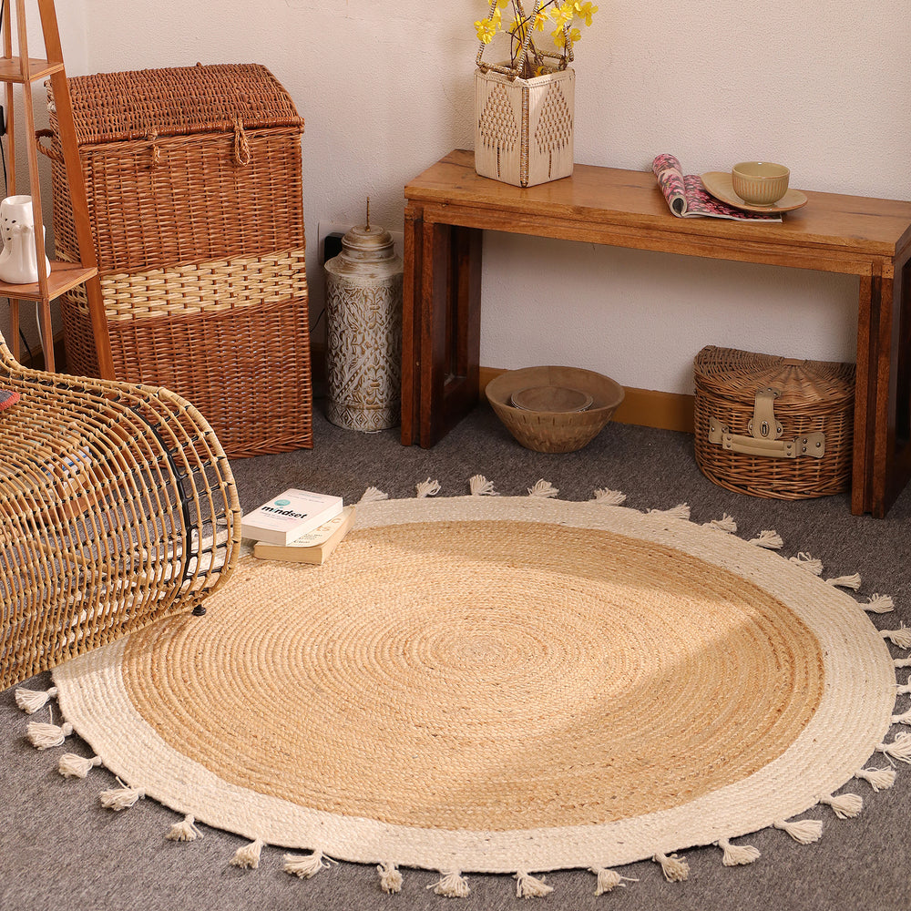 Handwoven round natural jute rug with ivory white braided border and tassel fringe for boho farmhouse home décor.