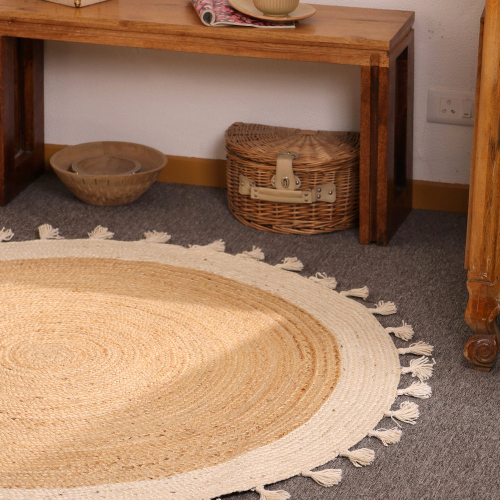 Handwoven round natural jute rug with ivory white braided border and tassel fringe for boho farmhouse home décor.