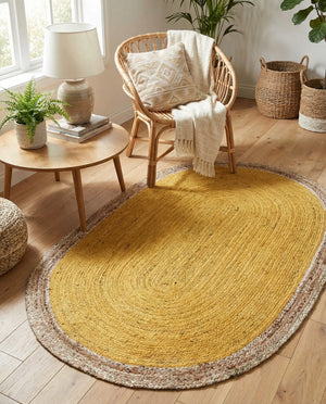 Handwoven oval jute area rug in mustard yellow with a natural beige braided border